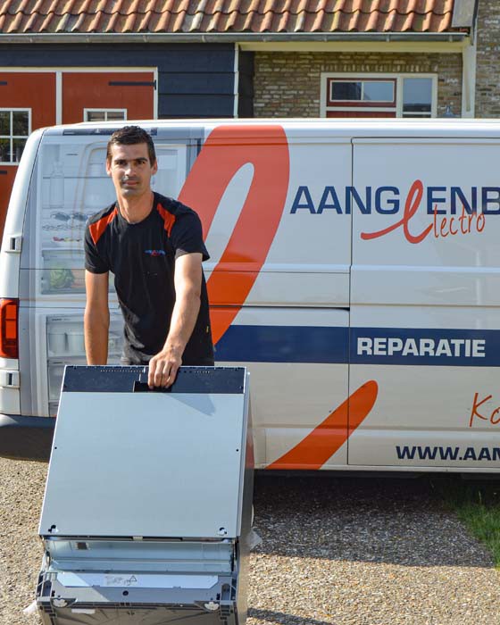 Monteur staat met gereedschapskoffer voor een huis voor witgoedreparatie.